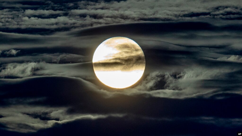 The full moon shines surrounded by clouds in the outskirts of Frankfurt, Germany, early Wednesday, Sept. 2, 2020. 