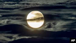 In this file photo the full moon shines surrounded by clouds on the outskirts of Frankfurt, Germany, September 2, 2020. (AP Photo / Michael Probst)