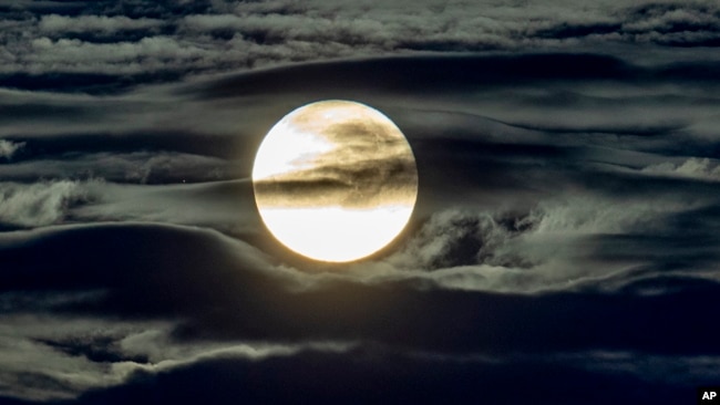 In this file photo, the full moon shines surrounded by clouds in the outskirts of Frankfurt, Germany, Sept. 2, 2020. (AP Photo/Michael Probst)