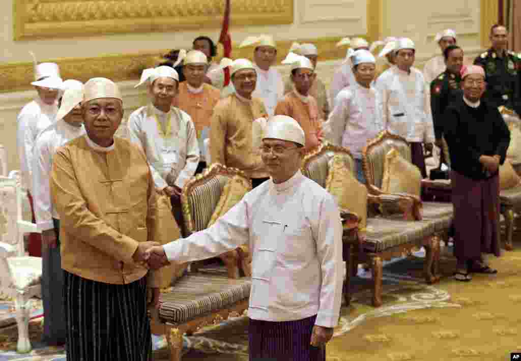 Myanmar&#39;s new president Htin Kyaw, left, shakes hands with outgoing president Thein Sein, during a handover ceremony in Naypyitaw.