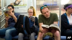 Subway riders read books, May 15, 2018 in New York. (AP Photo/Mark Lennihan)