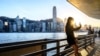 A woman takes a selfie in front of the Hong Kong skyline on November 26, 2024.