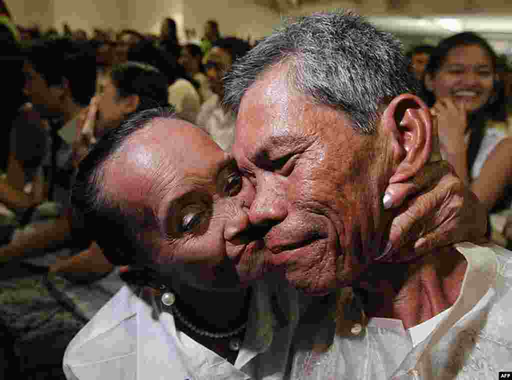 A 66-year-old bride kisses her 54-year-old groom during a mass wedding ceremony as part of a Valentine's Day celebration in Paranaque, Metro Manila February 14, 2012. (REUTERS)