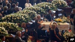 Relatives attend a funeral service for some of the victims of a collapsed highway bridge, in Genoa's exhibition center Fiera di Genova, Italy, Aug. 18, 2018. 