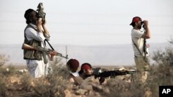 Rebel fighters patrol in the desert south of the Libyan rebel-held town of Chakchuk in the Western Mountains, some 160 km (99.4 miles) southwest of Tripoli, June 4, 2011.