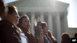 Leónida Martínez, de Phoenix, Arizona, segunda desde la izquierda, y otras personas se manifiestan en las afueras de la Corte Suprema de Justicia, en Washington.