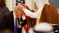 El rey Salman coloca el Collar de Abdulaziz Al Saud, la más alta condecoración saudí, al presidente Donald Trump. 