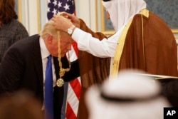 Saudi King Salman presents President Donald Trump with The Collar of Abdulaziz Al Saud Medal at the Royal Court Palace, Saturday, May 20, 2017, in Riyadh.