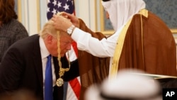 Saudi King Salman presents President Donald Trump with The Collar of Abdulaziz Al Saud Medal at the Royal Court Palace, Saturday, May 20, 2017, in Riyadh.