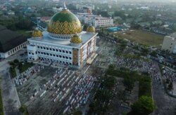 Foto udara menunjukkan umat Islam Indonesia melaksanakan salat Idul Adha di sebuah masjid di tengah lonjakan kasus COVID-19 di Palangkaraya, Kalimantan Tengah, 20 Juli 2021. (Foto: Antara/Makna Zaezar via Reuters)