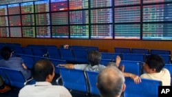 In this photo taken Monday, Sept. 10, 2012, investors and brokers are seen at the Asia Commercial Bank (ACB) Stock Exchange in Hanoi, Vietnam.