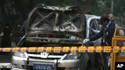 Police and forensic officials examine a damaged Israeli embassy car after an explosion in New Delhi February 13, 2012.