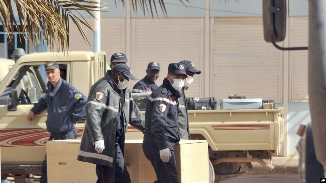 Algerian firemen carry a coffin containing a person killed during the gas facility hostage situation, at the morgue in Ain Amenas, Algeria, January 21, 2013.