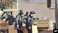 Algerian firemen carry a coffin containing a person killed during the gas facility hostage situation, at the morgue in Ain Amenas, Algeria, January 21, 2013.