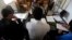 In this April 3, 2018 photo, a Syrian 19-year-old former member of the Islamic State group, who declined to be identified, sits opposite a panel of three judges, in the courtroom of a Kurdish-run terrorism court, in Qamishli, north Syria. 