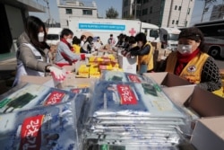Red Cross workers fill emergency relief kits with basic necessities like instant food for delivery to impoverished people amid the spread of the new coronavirus at a facility of the Korean National Red Cross in Seoul, South Korea, March 20, 2020.
