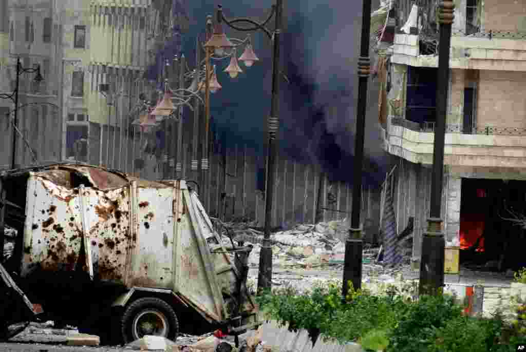 A citizen journalism image of black smoke rising from a building hit by Syrian government shelling, Aleppo, March 19, 2013.