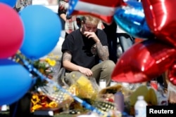 Bry Thompson wipes away tears at a makeshift memorial in the middle of Las Vegas Boulevard following the mass shooting in Las Vegas, Nevada, Oct. 4, 2017.