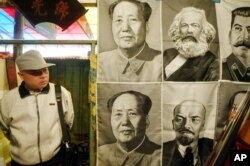 一路人观看在北京一市场里悬挂的共产主义领袖像。