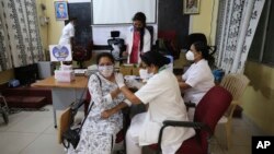 印度醫護人員在班加羅爾一所醫院給居民接種新冠疫苗。 （2021年4月1日）
