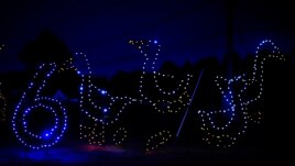 Holiday lights depicting geese shine at the Cumberland Fair Grounds, Tuesday, Dec. 14, 2021, in Cumberland, Maine. (AP Photo/Robert F. Bukaty)