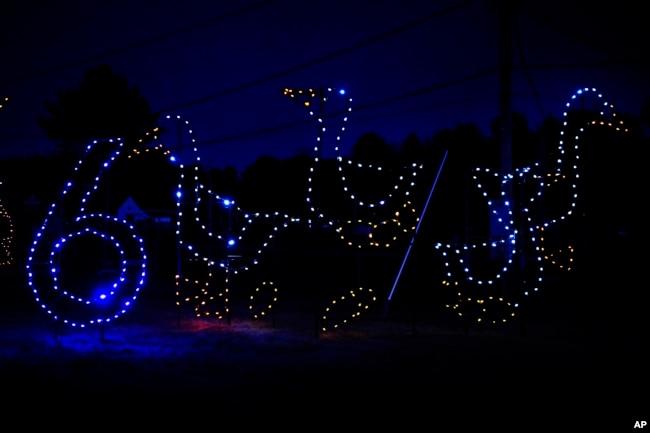 Holiday lights depicting geese shine at the Cumberland Fair Grounds, Tuesday, Dec. 14, 2021, in Cumberland, Maine. (AP Photo/Robert F. Bukaty)