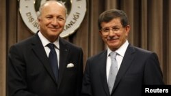 Turkish Foreign Minister Ahmet Davutoglu (R) and his French counterpart Laurent Fabius shake hands after a news conference in Ankara August 17, 2012.