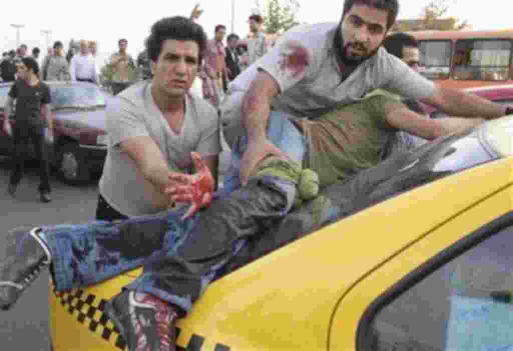 A man lies on the back of a taxi, after being seriously injured by gunfire in an area where pro-government militia were firing shots in the air at a rally supporting leading opposition presidential candidate Mir Hossein Mousavi in Tehran, Iran, Monday, Ju