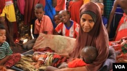 A mother holds her baby at Hagadera transit camp in Kenya’s Dadaab refugee camp, Sept. 20, 2016. (J. Craig/VOA)