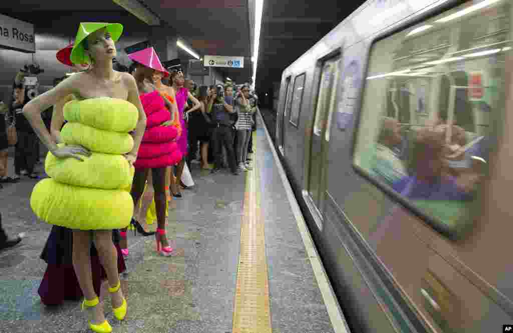 Models wearing collections of previous editions of the Sao Paulo Fashion Week, stand inside a subway station in Sao Paulo, Brazil, Oct. 27, 2013. 