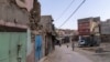 People walk past buildings that were affected by the 2023 earthquake in the town of Amizmiz, outside Marrakech, Morocco, Sept. 4, 2024.