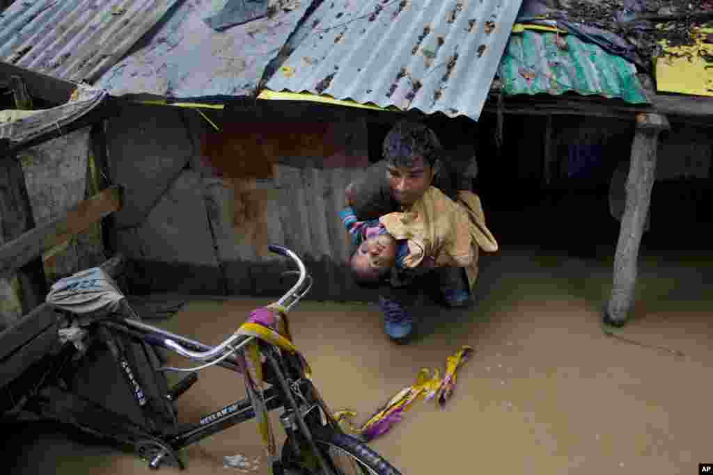 An Indian man carries a boy to move to a safer place after their neighborhood was flooded in Srinagar, Indian controlled Kashmir.