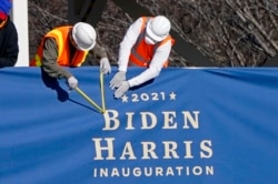 Workers put up bunting on a press riser for the upcoming inauguration of President-elect Joe Biden and Vice President-elect Kamala Harris, on Pennsylvania Ave. in front of the White House, Thursday, Jan. 14, 2021, in Washington. (AP Photo/Gerald Herbert)