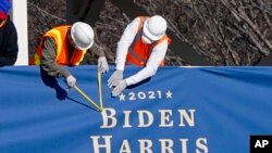 Workers put up bunting on a press riser for the upcoming inauguration of President-elect Joe Biden and Vice President-elect Kamala Harris, on Pennsylvania Ave. in front of the White House, Thursday, Jan. 14, 2021, in Washington. (AP Photo/Gerald Herbert)