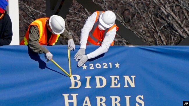 Workers put up bunting on a press riser for the upcoming inauguration of President-elect Joe Biden and Vice President-elect Kamala Harris, on Pennsylvania Ave. in front of the White House, Thursday, Jan. 14, 2021, in Washington. (AP Photo/Gerald Herbert)