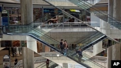 FILE - In this April 10, 2014 photo, people ride up and down the escalators inside the Sambil mall in Caracas, Venezuela. (AP Photo/Fernando Llano)