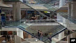 FILE - People ride the nearly empty escalators inside the Sambil mall in Caracas, Venezuela. 