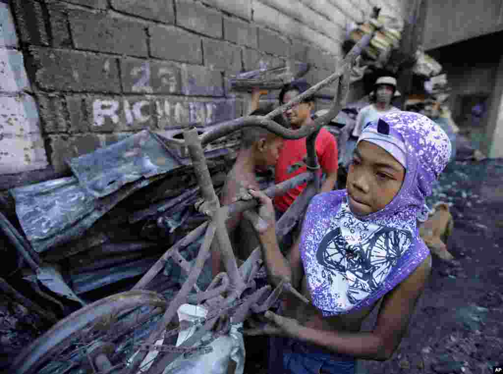 A boy, who lost his home in a huge fire on New Year&#39;s day, carries a burnt bicycle at suburban Quezon city, north of Manila, Philippines. The fire, believed to have been ignited by firecrackers, razed hundreds of homes Thursday in one of more than a dozen fires reported across the country as Filipinos welcomed the New Year.