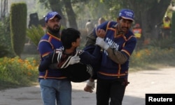 Rescue workers assist an injured student from the shooting at Directorate of Agriculture Institute in Peshawar, Pakistan, Dec. 1, 2017.