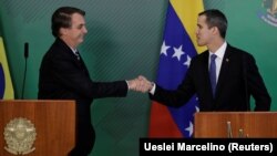 Jair Bolsonaro (esq) e Juan Guaidó (dir) cumprimentam-se em Brasília