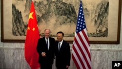U.S. National Security Adviser Tom Donilon, left, and Chinese State Councilor Yang Jiechi, right, shake hands before their meeting at Diaoyutai State Guesthouse in Beijing, May 27, 2013.