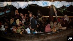 Rohingya refugees sit in a wooden boat as it arrives at Krueng Geukueh Port in North Aceh, Indonesia, Dec. 31, 2021. 
