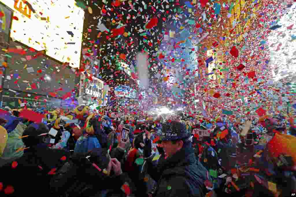 نئے سال کے جشن کے شرکا پر نیویارک کے ٹائمز اسکوائر میں رنگ برنگی جھنڈیاں نچھاور کی جا رہی ہیں۔