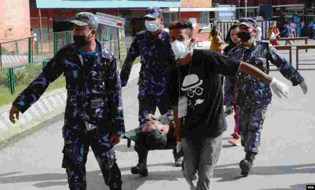 A injured man is carried into Teaching Hospital, Kathmandu, May 12, 2015. (Photo: Bikas Rauniar for VOA)