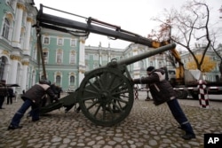 Workers install a gun in the yard of the Winter Palace in the State Hermitage Museum in St.Petersburg, Russia, Oct. 24, 2017, as part of preparations for an exhibition marking the centenary of the October Revolution.