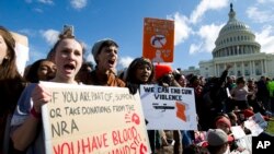 Students hold up their signs during a rally asking for gun control outside of the U.S. Capitol building, in March 14, 2018, in Washington. 