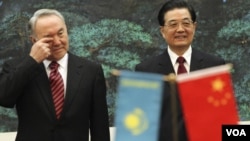 Presiden Kazakhstan Nursultan Nazarbayev (kiri) bersama Presiden Tiongok Hu Jintao di Beijing.