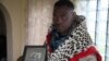 Chief Zanomthetho Mtirara poses with his leopard skin and a young picture of his adoptive "grandfather" Nelson Mandela, who was taken in by the Thembu royal family at the age of 9 when his father died. A leopard skin like this one will be draped over Mandela's coffin to show he was a royal chief. (Hannah McNeish for VOA) 