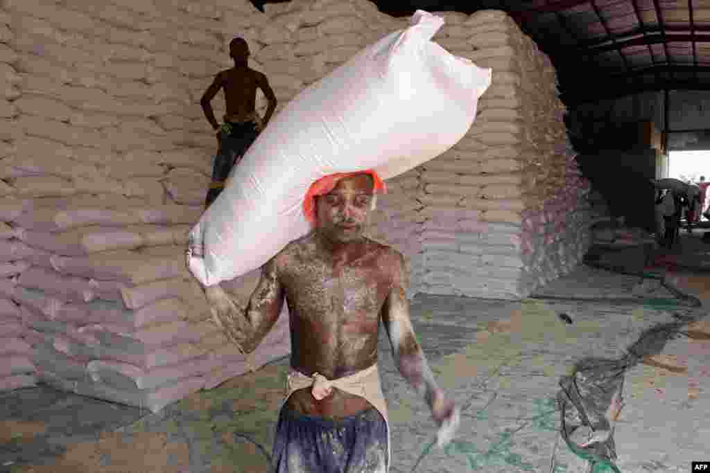 An aid worker carries a sack of flour in the northern province of Hajjah, Sept. 25, 2018, as Yemenis displaced from the port city of Hodeidah receive humanitarian aid donated by the World Food Program (WFP).