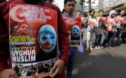 Pengunjuk rasa Muslim memegang spanduk selama rapat umum di luar kedutaan besar Tiongkok di Jakarta, 21 Desember 2018. (Foto: AP)